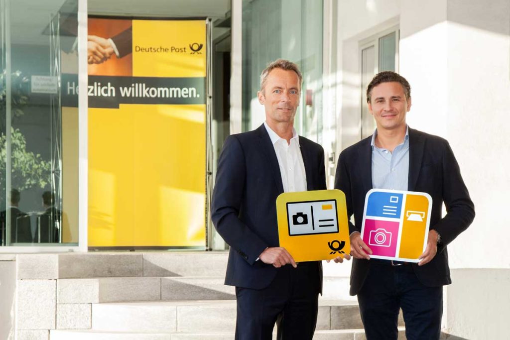 Oliver Kray (MyPostcard) und Kai Schmude (Deutsche Post) halten Icons