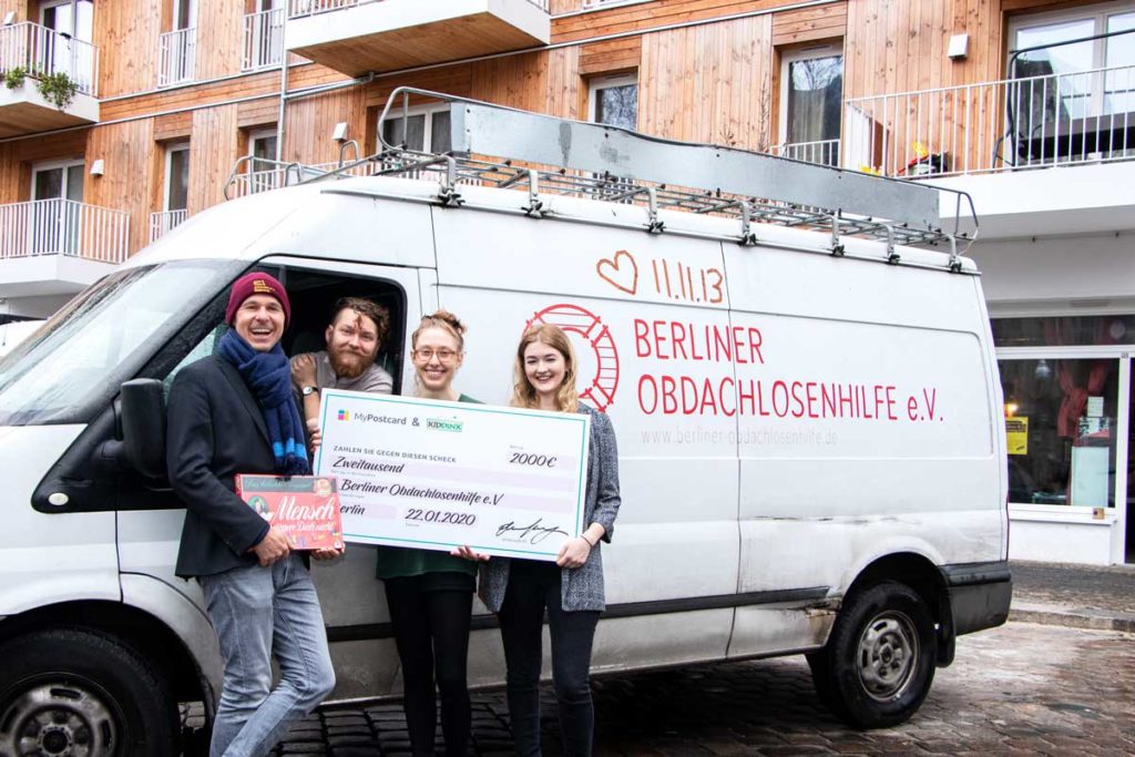 Advent für alle: MyPostcard und KIDDINX übermitteln Spendenerlöse an Berliner Obdachlosenhilfe Scheckübergabe Bus Menschen